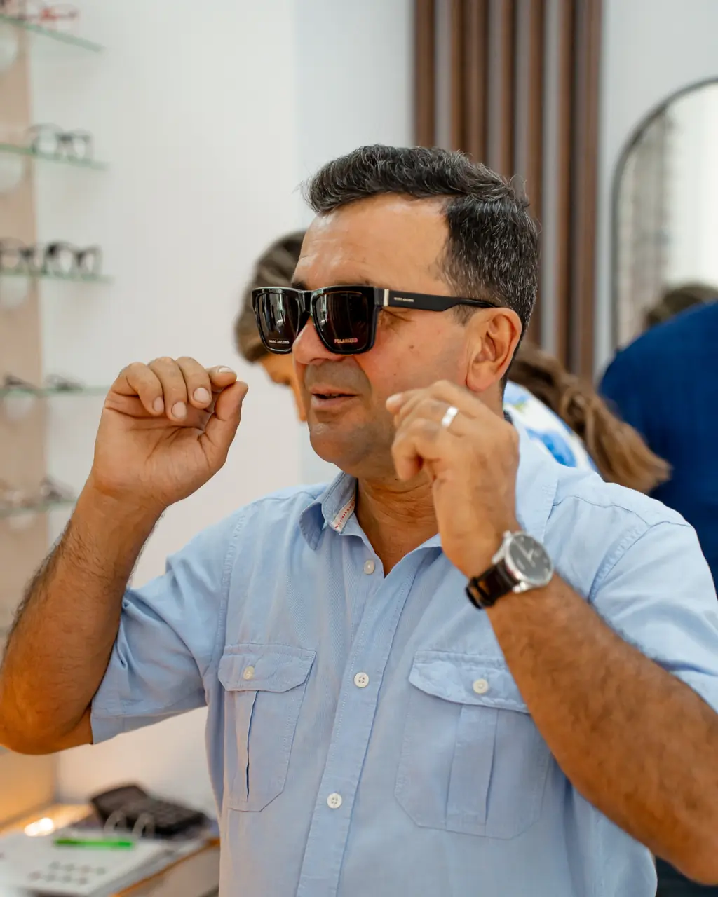Client care își potrivește ochelarii de soare